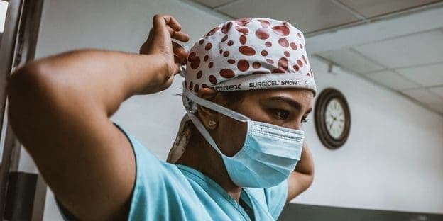 medical practitioner wearing hospital cap and mask